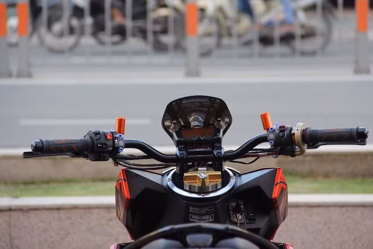 Điểm độc đáo nhất của bản độ này là thay vì phần đầu nguyên bản, chiếc Click 125i đã được trang bị ghi-đông kèm gù trần của Rizoma, khiến nó có dáng và tư thế ngồi của một chiếc naked bike thực sự. Nằm phía trên tay lái là đồng hồ Koso Mini 3 và DB-03, cùng với trợ lục Ohlins trung tâm.