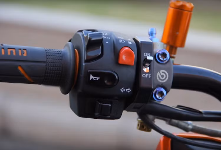 Nằm hai bên tay lái của xe cũng là một loạt các phụ tùng cao cấp. Ở bên tay trái của chiếc xe là cùm công tắc tổng Domino, công tắc on-off Daytona, cùm phanh Brembo kèm bình dầu Bonamici và tay phanh CRG Carbon.