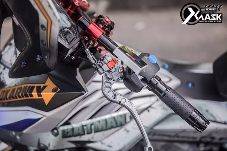 Một điểm đặc biệt của bản độ Winner 150 này đó là phần đầu nguyên bản của xe đã bị loại bỏ hoàn toàn, thay vào đó là ghi-đông trần. Nằm phía trên tay trái cũng là nhiều món "đồ chơi" như bao tay Rizoma Lux, cùm công tắc độ, cùm côn CRG và đồng hồ Koso Mini 3.