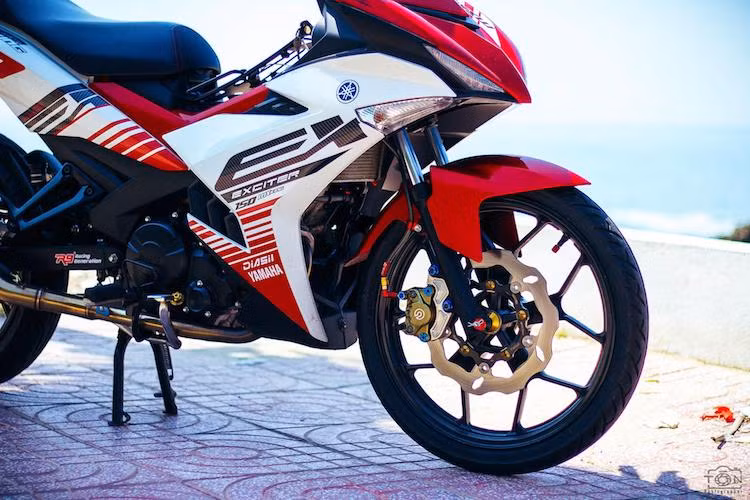 Ở phía trước, hệ thống phanh nguyên bản của Exciter đã được chủ xe nâng cấp hoàn toàn, sử dụng các phụ tùng như heo Brembo 2 pis đối xứng, đĩa Galfer và dây dầu Earl's. Thay vì bộ mâm 5 cánh kép đúc nguyên bản, chiếc xe đã có "dàn chân" mới với mâm chữ Y được thiết kế tương tự Yamaha R3.