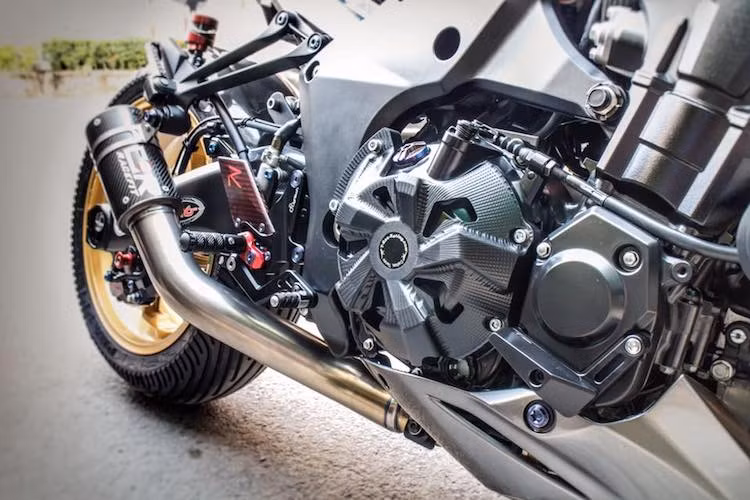 Khối động cơ nguyên bản của Z1000 được giữ nguyên, chỉ độ lại hệ thống xả titan, đồng thời được bảo vệ thêm bằng những chi tiết ốp bưởng máy CNC và chống đổ. Lùi về phía sau một chút là dàn để chân Lightech R Version, tạo điểm bắt pen đạp phía sau Brembo Billet.