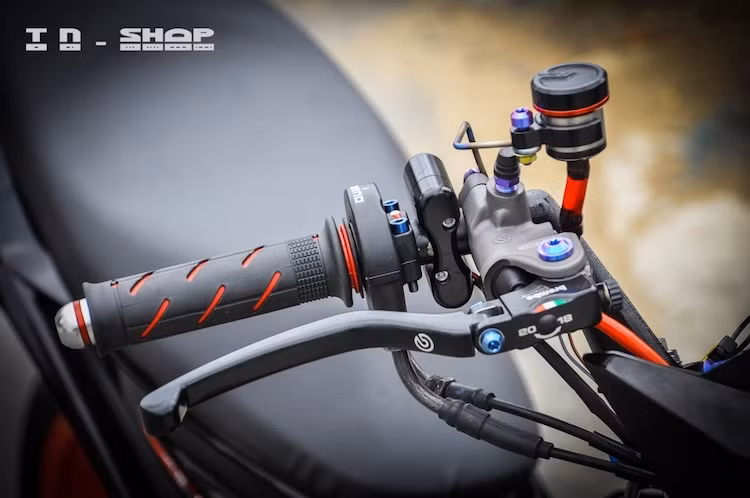 Ở bên phải, chiếc xe cũng đã được chủ nhân nâng cấp cùm phanh Brembo RCS đem tới cảm giác phanh thật hơn, kết hợp cùng với bình dầu AEM TItanium. Bên cạnh là cùm công tắc Daytona và cùm ga cuốn Domino.