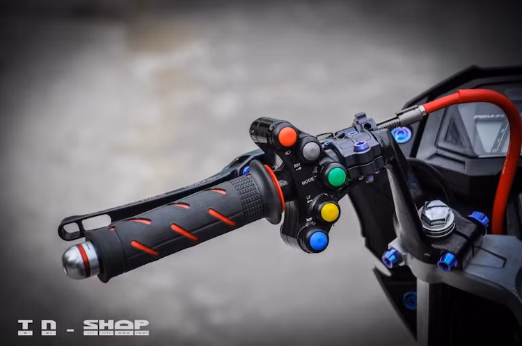 Nằm ở trên cụm ghi-đông clip-on cũng là hàng loạt các phụ tùng cao cấp. Ở phía bên trái có sự xuất hiện của tay côn CRG, cùm công tắc Daytona phong cách MotoGP, gù Rizoma và bao tay Domino.