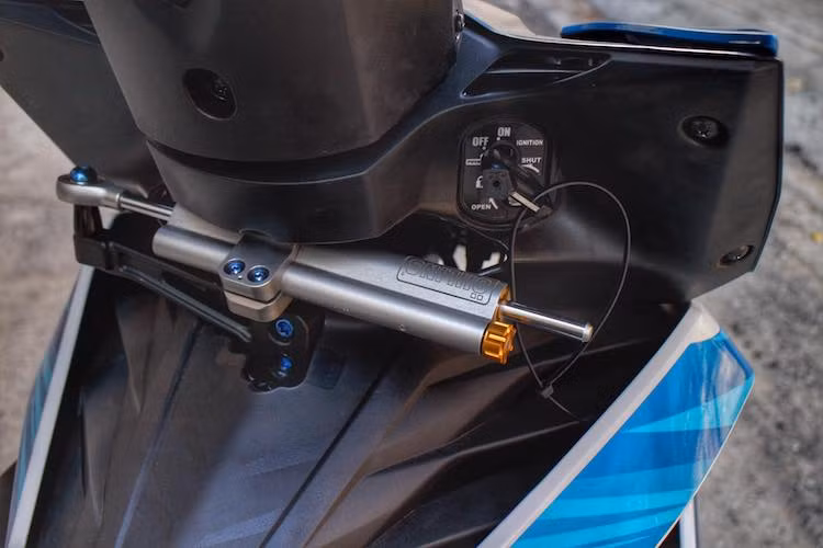 Ở bên dưới phần gáy của chiếc xe, một cây trợ lực Ohlins 68 mm đã được chế khéo léo vào Winner bằng cách khoét nhựa và chế pad nhôm CNC. Với chi tiết này, phần đầu xe sẽ trở nên ổn định hơn ở tốc độ cao.