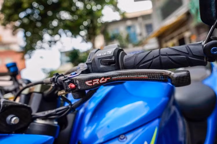 Ở bên tay lái phải cũng có bao tay Spider, bên cạnh đó là cùm côn CRG Carbon Raceline và gương chiếu hậu CRG Arrow. Nằm trên bình xăng của xe là nắp xăng Lightech đóng mở nhanh theo phong cách xe đua. Trước đầu xe còn có cặp xi-nhan Motogadget Pin với kích thước nhỏ gọn.