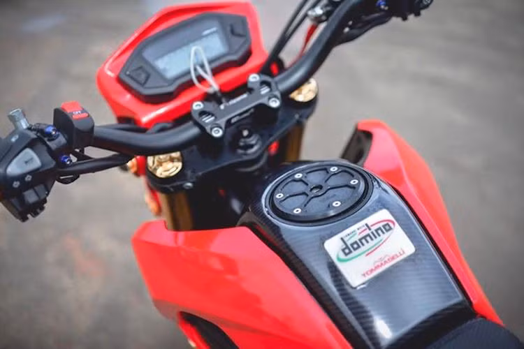 Với cùm ghi-đông và tay lái Rizoma, chiếc MSX125 đã có tư thế ngồi càng thoải mái hơn so với nguyên bản. Ở phía trên bình xăng "zin" của xe, phần ốp nhựa nhám đã được phủ lớp sợi carbon thật, trong khi nắp xăng cũng đã được ốp trang trí bởi tấm ốp nhôm CNC sắc sảo.