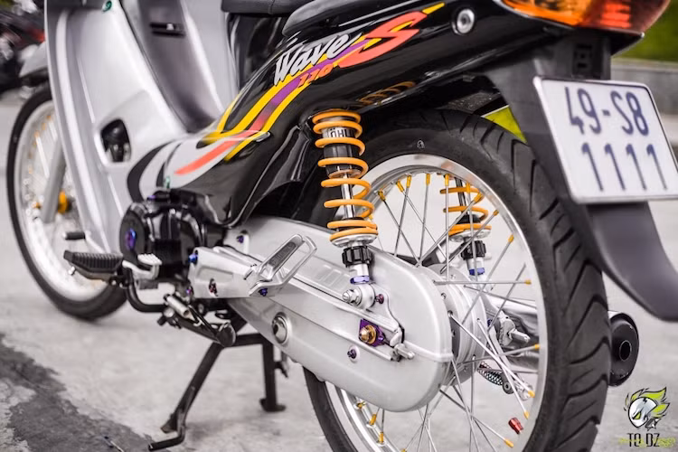 Một số con ốc titan được bắt ở nhiều chi tiết cũng khiến cho chiếc Wave kiểng này trở nên long lanh hơn. Dù hệ thống phanh sau vẫn giữ lại phanh đùm nguyên bản, tuy nhiên cặp phuộc Ohlins lại là một nâng cấp đáng giá để giúp cho chiếc Wave vận hành ổn định hơn trên đường.