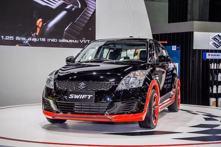 So với những chiếc xe còn lại tại Bangkok International Auto Salon, chiếc Swift này khá đặc biệt khi được độ thành xe crossover với nẹp nhựa màu đỏ ốp quanh thân xe đầy "cơ bắp". Hệ thống treo của xe cũng được nâng hành trình, khiến các bánh xe với mâm Volk TE37 không bị chạm hốc bánh khi vượt qua địa hình.