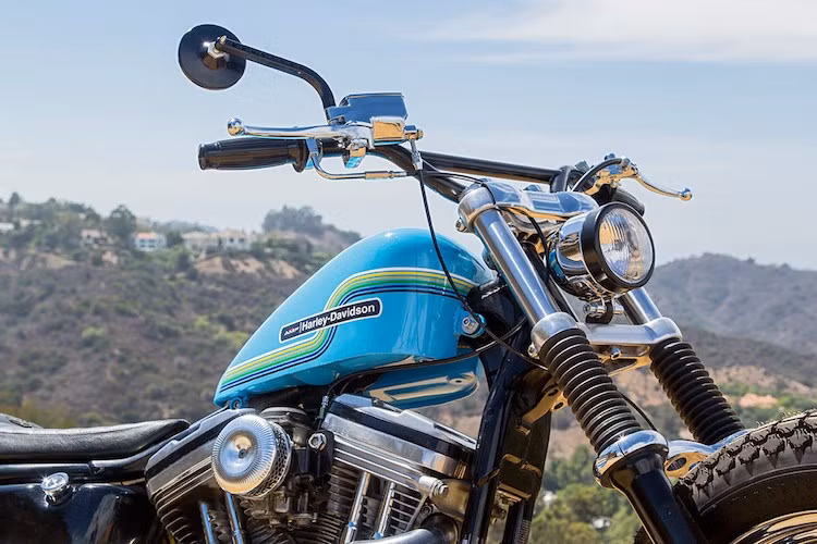 Phần tay lái với ghi-đông cao được Clint mua từ hãng MOTO. Đối với bình xăng, anh đã phải mất một thời gian để tìm kiếm một chiếc bình có hình hạt đậu, sau đó sơn màu xanh, dán tem Vintage AMF lên và cuối cùng phủ lại bằng một lớp sơn bóng.