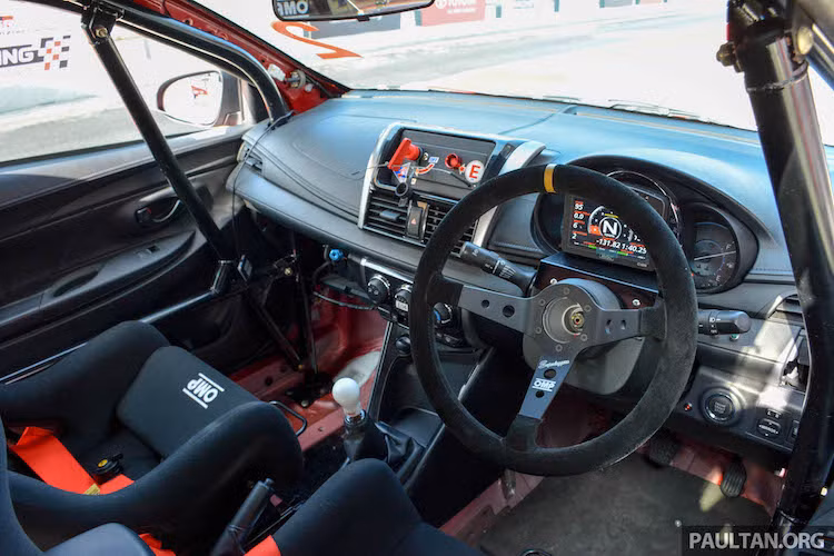 Bên trong nội thất, Vios Challenge chỉ còn giữ lại bảng táp-lô cùng các tấm ốp cửa nguyên bản. Bảng đồng hồ kỹ thuật số đa thông tin của Motec được gắn trước đồng hồ nguyên bản, trong khi vô-lăng của xe là loại siêu nhẹ Superleggera của hãng OMP.