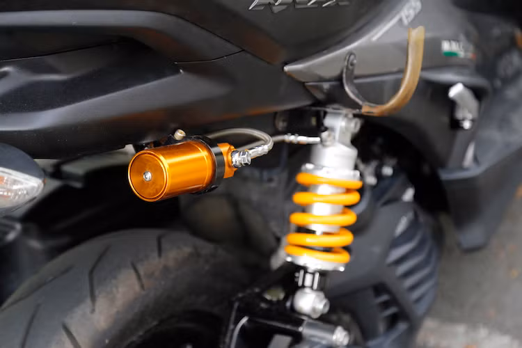 Ở phía sau, hệ thống giảm xóc đôi nguyên bản trên NVX 155 đã được độ lại thành phuộc đơn monoshock, với cây phuộc bình dầu rời để đảm bảo độ chắc chắn dù đặt lệch bên phải xe. Khối động cơ xi-lanh đơn SOHC 4 van 155 cc của xe không có sự thay đổi.