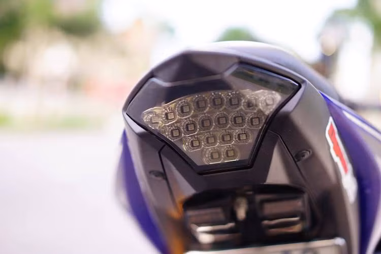 Chiếc R3 nguyên bản có cụm chắn bùn kèm pad biển số và xi-nhan khá xấu, chính vì vậy chủ xe đã loại bỏ toàn bộ các chi tiết này. Không chỉ có pad biển số và xi-nhan giấu gọn dưới gầm, chiếc xe còn được trang bị cụm đèn hậu LED với chóa màu khói sáng và ấn tượng hơn.