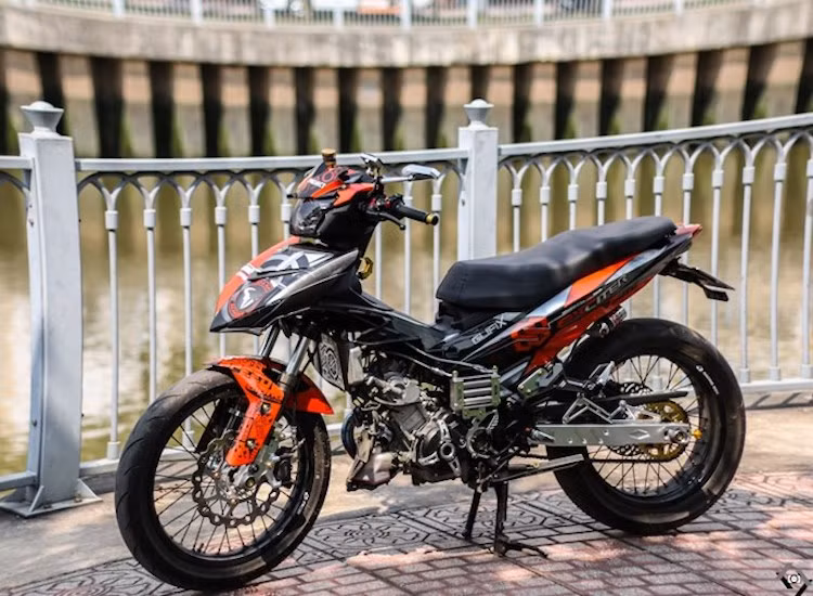 Toàn bộ phần yếm ở hai bên thân xe đã được chủ nhân tháo bỏ để khiến chiếc Exciter "trơ máy", trở nên góc cạnh hơn. Một dàn tản nhiệt dầu được gắn thêm vào ở bên cạnh chiếc xe.