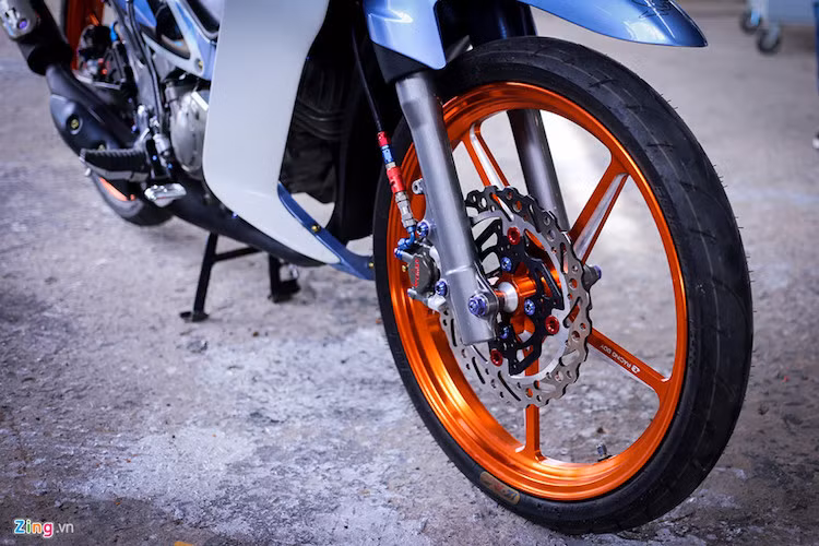 Dàn chân của Yamaha 125Z cũng được thay thế so với nguyên bản. Vành xe hiệu Racing Boy màu cam nổi bật. Trong khi đó hệ thống phanh đĩa là sản phẩm của Brembo.