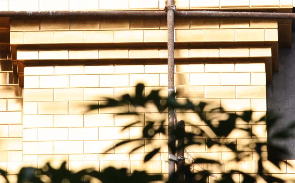 Những phần tường bề mặt bên ngoài của dự án dần dần được ốp gạch vàng.