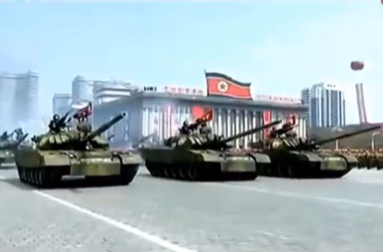 Dẫn đầu đội hình vũ khí Quân đội Triều Tiên duyệt binh là khối xe tăng chiến đấu chủ lực – có thể là loại “Bão phong hổ” được lắp thêm khối giáp phản ứng nổ (ERA). Nguồn ảnh: KCTV