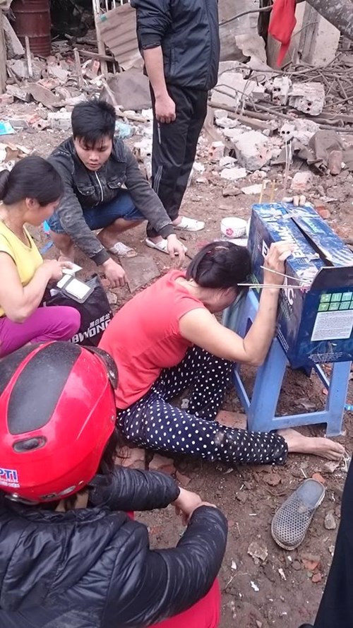 Hình ảnh thảm khốc vụ nổ nghi do “cưa bom” ở Văn Phú, Hà Đông. Trong ảnh là người vợ chủ cửa hàng thu mua phế liệu đang khóc ngất cạnh chiếc hộp đựng những phần thi thể còn xót lại của người chồng “đùa giỡn với tử thần”. Ảnh: Tiền Phong