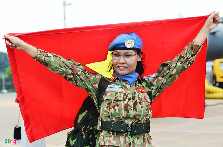 Nữ quân nhân, đại úy Phạm Thị Thu Trang tự hào chụp với lá cờ Tổ quốc sẽ tung bay trên nước bạn trong thời gian tới.
