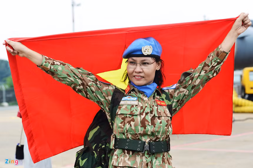 Nữ quân nhân, đại úy Phạm Thị Thu Trang tự hào chụp với lá cờ Tổ quốc sẽ tung bay trên nước bạn trong thời gian tới.