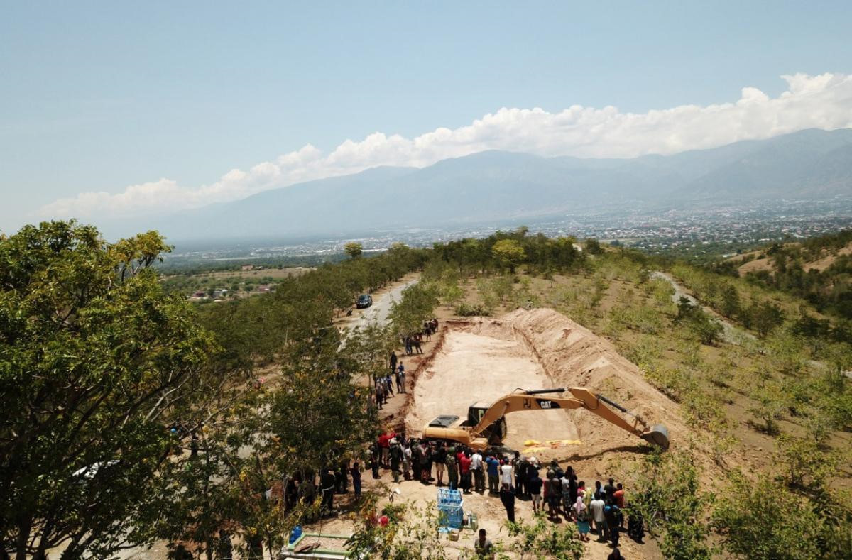 Chính quyền địa phương phải gấp rút cho chôn cất thi thể các nạn nhân để ngăn chặn dịch bệnh bùng phát. Các thi thể được đặt trong những túi màu vàng, cam và đen chở trong 3 xe tải đưa lên đồi Poboya, theo mô tả của phóng viên AFP. Ảnh: Reuters.Chính quyền địa phương phải gấp rút cho chôn cất thi thể các nạn nhân để ngăn chặn dịch bệnh bùng phát. Các thi thể được đặt trong những túi màu vàng, cam và đen chở trong 3 xe tải đưa lên đồi Poboya, theo mô tả của phóng viên AFP. Ảnh: Reuters.