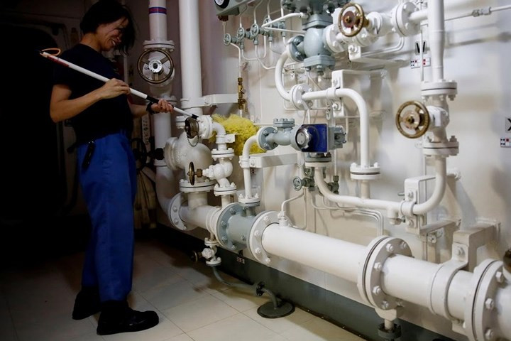 Nữ thủy thủ Nhật Bản này đang lau sạch các ống bên trong khu vực hành lang của tàu Kaga.