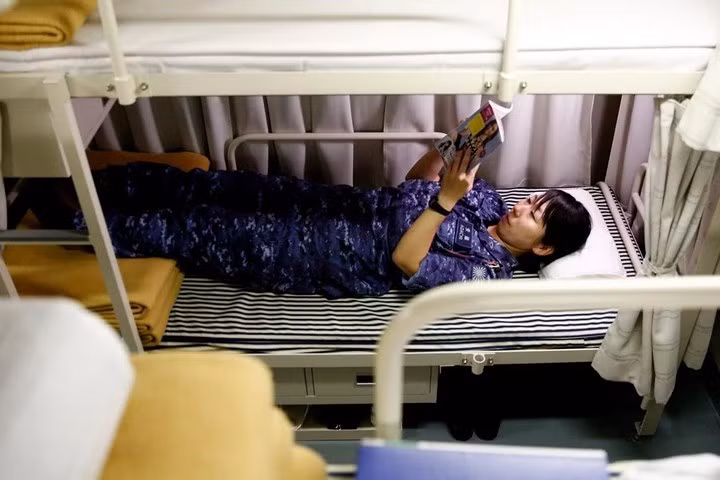 Nữ thủy thủy tranh thủ đọc sách trên giường trong giờ nghỉ trưa. Ở lối vào khu vực ngủ nghỉ của phụ nữ cũng có biển cảnh báo nam giới phải tránh xa, để ngăn chặn tình trạng quấy rối tình dục.