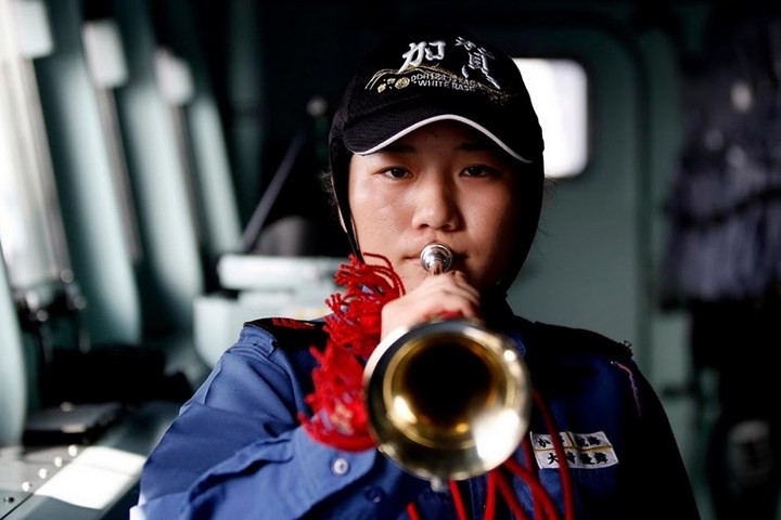 Nữ hoa tiêu Yuma Osaki thổi kèn trên cầu tàu Kaga khi tàu này di chuyển tới nơi diễn tập quân sự.
