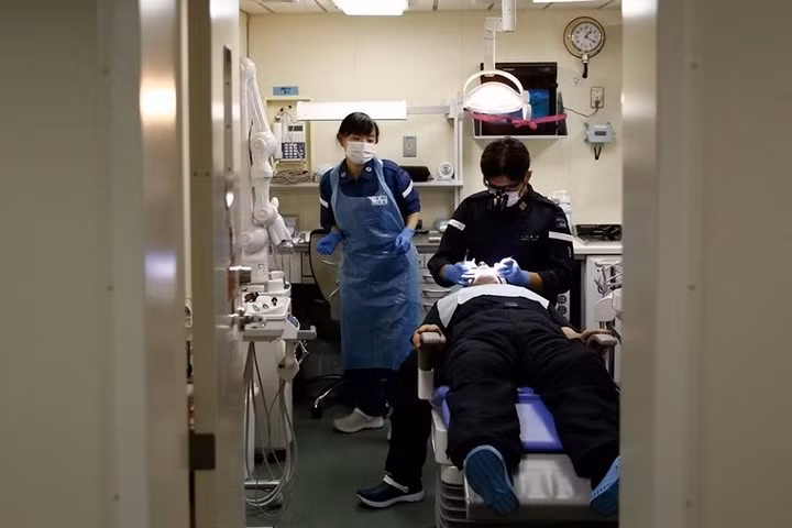 Nữ y tá hải quân Nhật Bản đang hỗ trợ cho bác sĩ nha khoa trên tàu chiến Kaga.