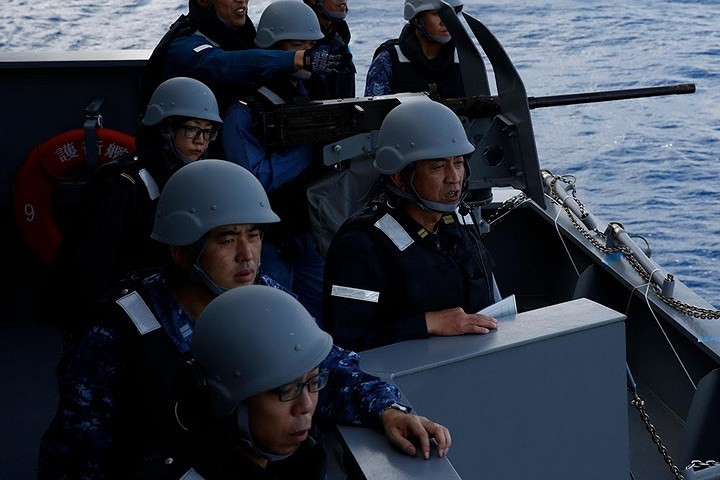 Một nữ thủy thủ Nhật Bản (đeo kính, bên trái) đang theo dõi diễn tập bắn đạn thật bằng súng máy 12,7mm của tàu Kaga.