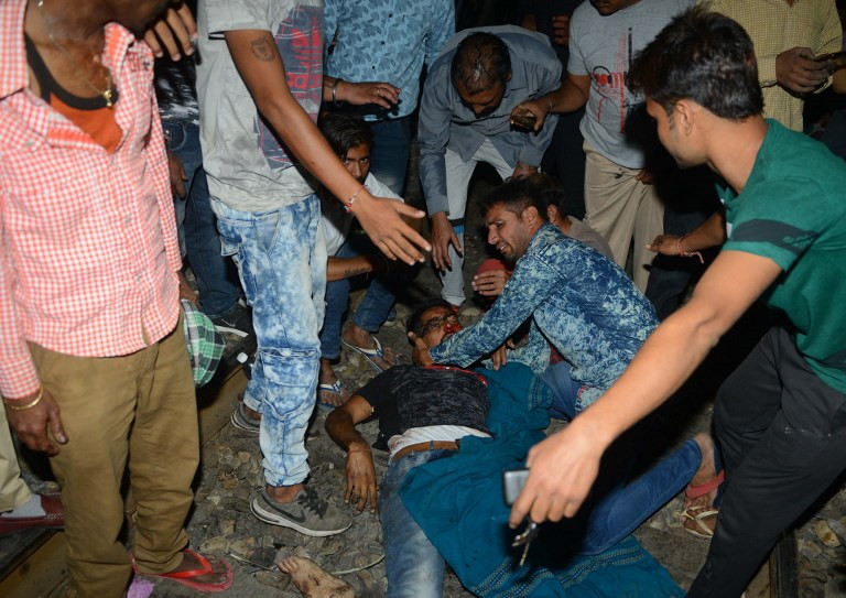 Tới sáng 20/10, nhà chức trách Ấn Độ xác nhận ít nhất 61 người thiệt mạng và 72 người bị thương trong vụ việc.Tại thời điểm xảy ra vụ tai nạn, khoảng 300 người có mặt tại hiện trường. Trong ảnh, các nhân chứng cố gắng sơ cứu một nạn nhân trong vụ tai nạn ở Amristar. Ảnh: AFP.
