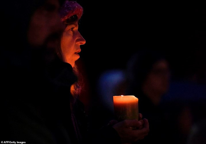 Một phụ nữ cầm nến tưởng niệm các nạn nhân bị thiệt mạng. Ảnh: Getty