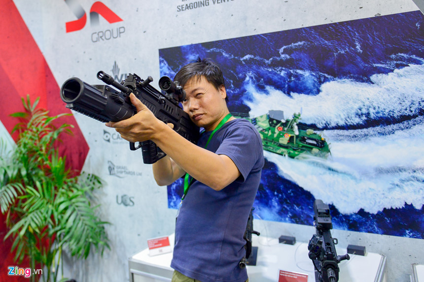Một khách tham quan triển lãm HSE 2018 ngắm bắn thử với súng trường tấn công TAR-21 với biến thể được gắn thêm súng phòng lựu 40mm và kính ngắm quanh học. Đây cũng là lần đầu tiên người dân Thủ đô được cầm thử trên tay các dòng súng bộ binh hiện đại nhất của Việt Nam. Nguồn ảnh: Zing.vn