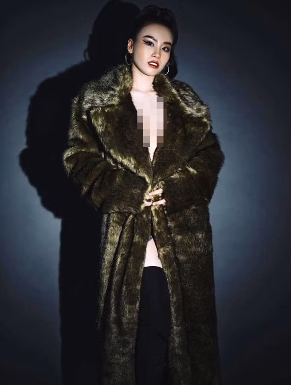 Trong hình, cô nàng chọn mặc chiếc áo lông màu xanh lục. Để tổng thể hài hòa, Linh Miu chọn đôi bốt đen cao ôm sát, trang điểm đậm, tóc búi cao cá tính.