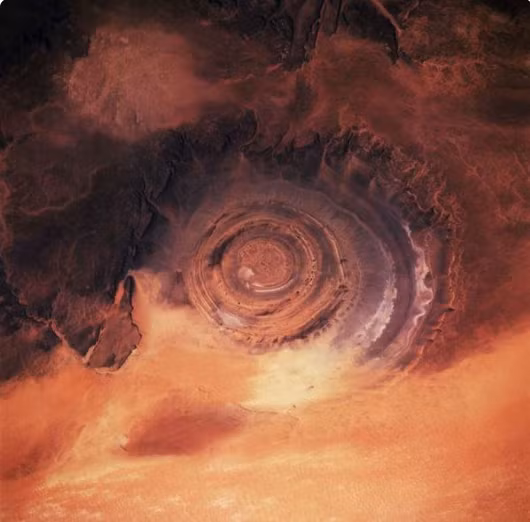 Nằm ở phía Tây sa mạc Sahara, địa hình có cấu trúc Richat này trông giống như một cái mắt rộng lớn, nên được gọi là Con mắt Sahara. Với các đường tròn đồng tâm có đường kính lên 50 km, cấu trúc mái vòm bị xói mòn này được đoán do tác động của tiểu hành tinh.