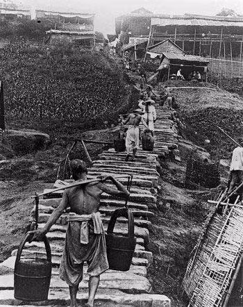 Những người dân nghèo gánh nước qua cây cầu ọp ẹp, tạm bợ. Ảnh news.china.com