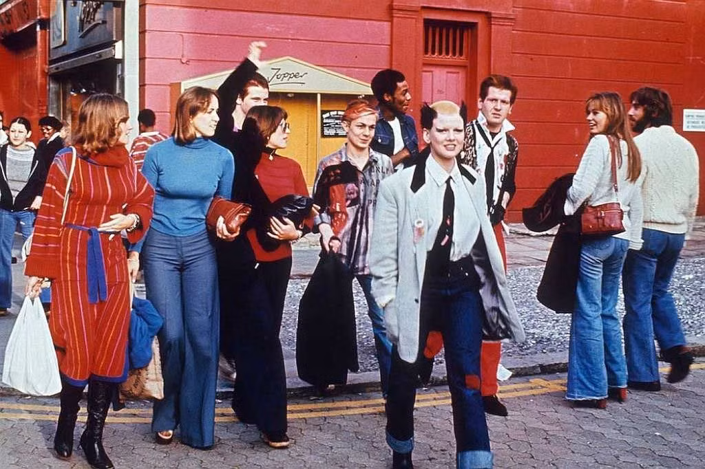 Mọi người đổ dồn mắt về những người ăn mặc có phần kì dị trên phố năm 1976. Ảnh OLA