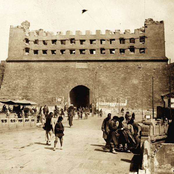 Dân thường và lính liên quân hiện diện bên ngoài một cổng thành.