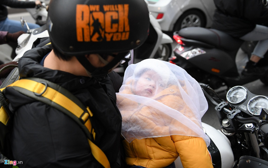 Còn Dũng vừa ngồi dưới lòng đường vừa dỗ con mới 7 tháng tuổi. Anh cho biết bà ngoại về quê sớm nên đi đâu cũng phải mang bé theo. Vợ anh đang ở trong cửa hàng giảm giá 70%, 20 phút rồi vẫn chưa thấy quay lại, trong khi đứa bé quấy khóc vì buồn ngủ.