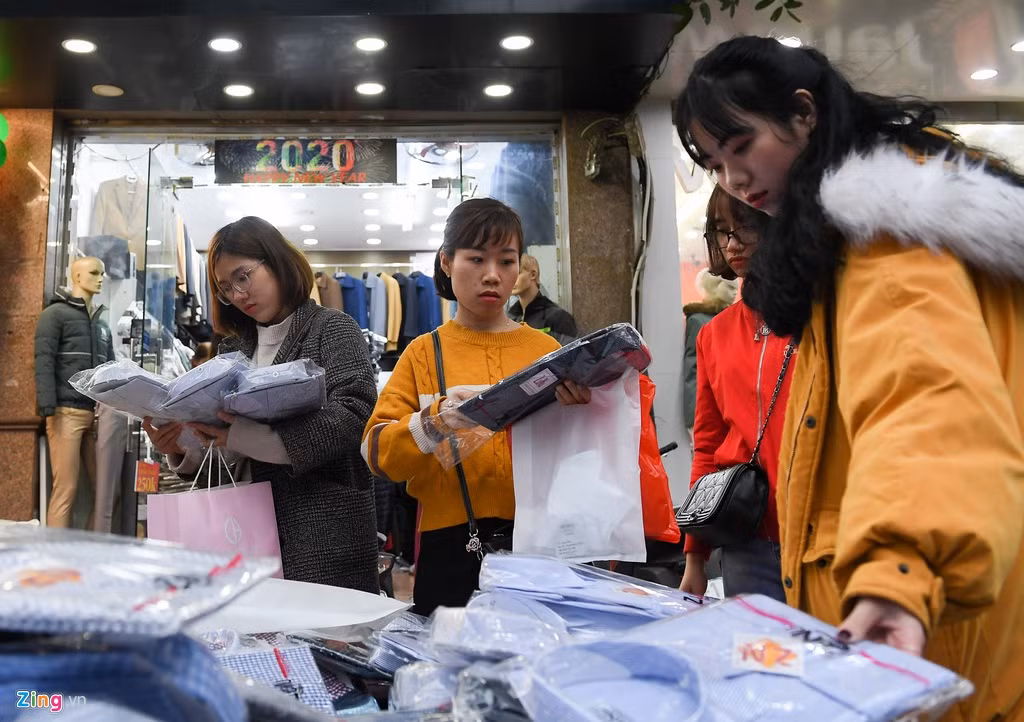 Những chiếc áo sơ mi có giá chỉ 100.000 đồng bày bán trên vỉa hè được nhiều người chọn mua. Chủ cửa hàng cho biết đây là hàng xuất khẩu thừa nên thanh lý giá rẻ.