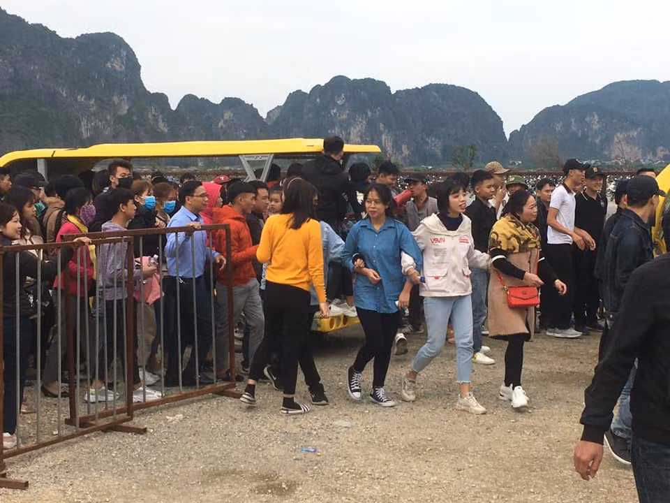 Tại điểm chờ xe điện, người dân xếp hàng dài chờ đợi. Do lực lượng bảo vệ quá mỏng, du khách đã tràn vào bên trong, chen nhau lên xe điện.