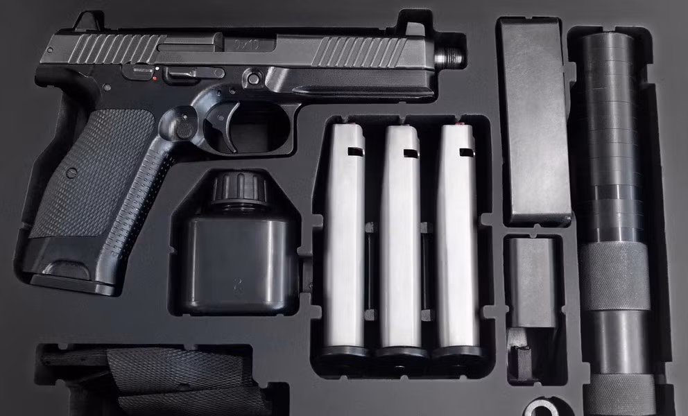 Súng có thân kim loại đen mờ, phần tay cầm có hình dáng tinh tế, như được đúc theo khuôn tay xạ thủ, tạo cảm giác dễ chịu cho người dùng.