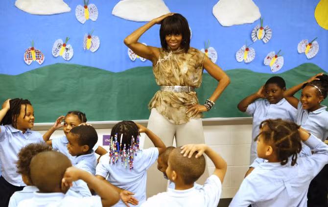 Đệ nhất phu nhân Mỹ đặt tay lên đầu khi nhảy cùng các em nhỏ tại trường Savoy ngày 24/5/2013.