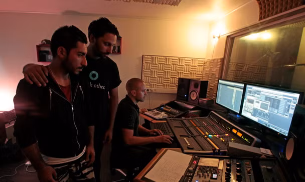 Anh luôn mong ước trở thành một ca sĩ. Một ngày, anh đã có cơ hội gặp nhà sản xuất người Pháp, Kerredine Soltani (giữa) gần khu trại tị nạn ở Porte de Saint-Ouen.