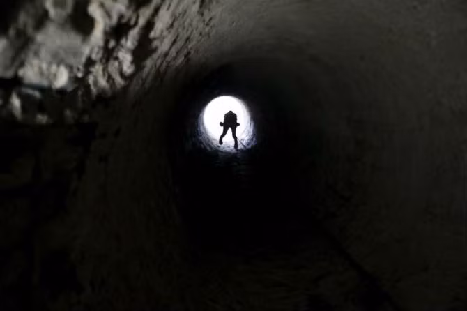 Một công nhân Palestine đu lên sợi dây để ra khỏi đường hầm ngày 2/11/2015.