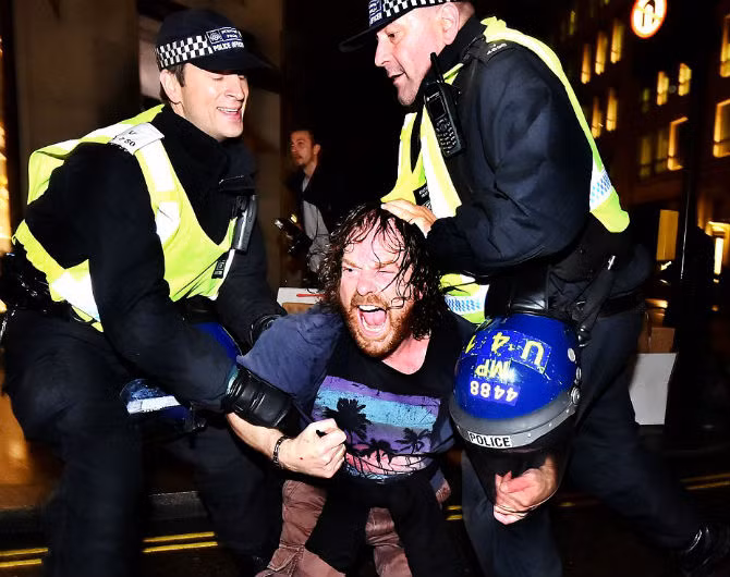 Hai cảnh sát khống chế một người đàn ông trên phố Regent ở thủ đô London, Anh trong đêm 5/11.