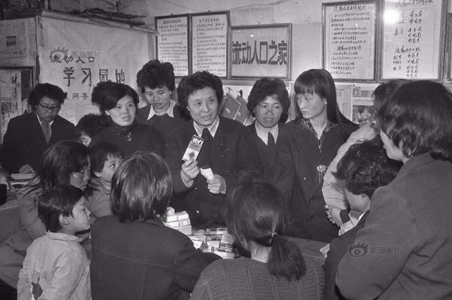 Bước vào thời kì cải cách và mở cửa, việc thực hiện chính sách một con cũng không được lơ là. Bức ảnh chụp năm 1991: Một nhân viên đang cung cấp thuốc tránh thai cho những cô gái ở thành phố Fuxin, tỉnh Liêu Ninh.