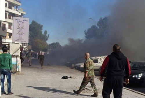 Ngày 10/11, ít nhất 23 người chết, 65 người bị thương khi một quả rocket rơi xuống gần một trường đại học của thành phố Latakia vốn được coi là thành trì Tổng thống Syria. Một quả rocket khác rơi trúng một trạm xe buýt. Ảnh: Khói đen bốc lên từ một khu vực bị trúng rocket ở Latakia.