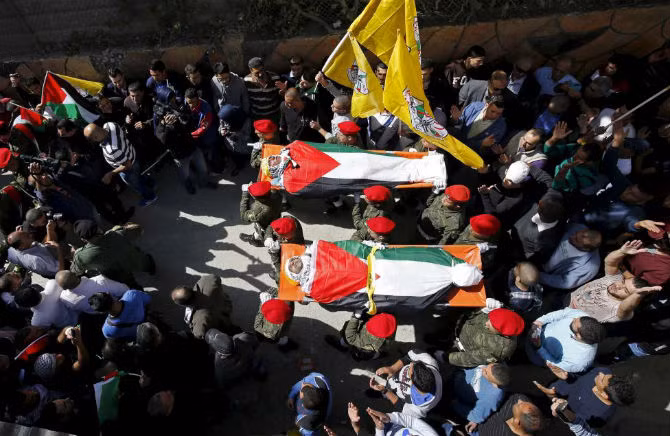 Thi thể của hai người Palestine được đưa trên đường phố ở làng Qatana, gần Jerusalem ngày 2/11. Theo giới chức Israel, hai người này liên quan đến vụ tấn công người Israel.