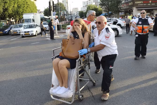 Một bác sĩ Israel đưa người phụ nữ bị thương ra khỏi hiện trường vụ tấn công tại Rishon Lezion, gần Tel Aviv, ngày 2/11. Một thanh niên Palestine 19 tuổi đến từ thành phố Hebron đã đâm ba người ở Rishon Lezion trước khi bị cảnh sát Israel bắn giữ.