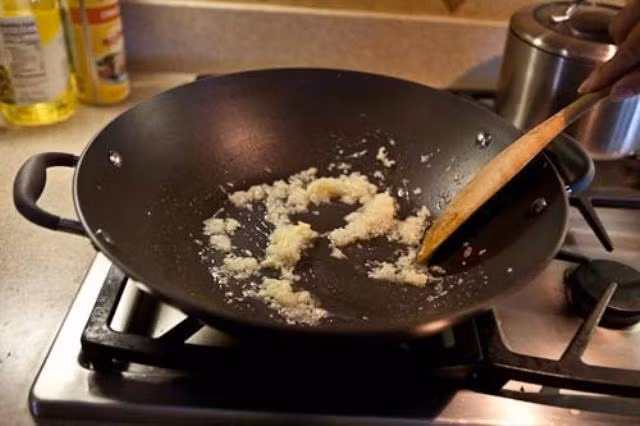 Bước 3: Phi thơm tỏi, gừng với dầu ăn rồi cho các gia vị vao gồm dầu hào, ớt bột, tương ớt, tương cà, giấm, đường, hạt tiêu và thêm một chút nước đảo cho sền sệt để làm nước sốt chân gà chua cay.